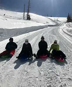 group sledding down snowy road