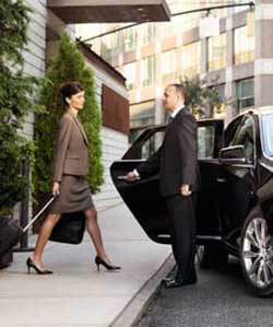 driver holding door of private car for business woman